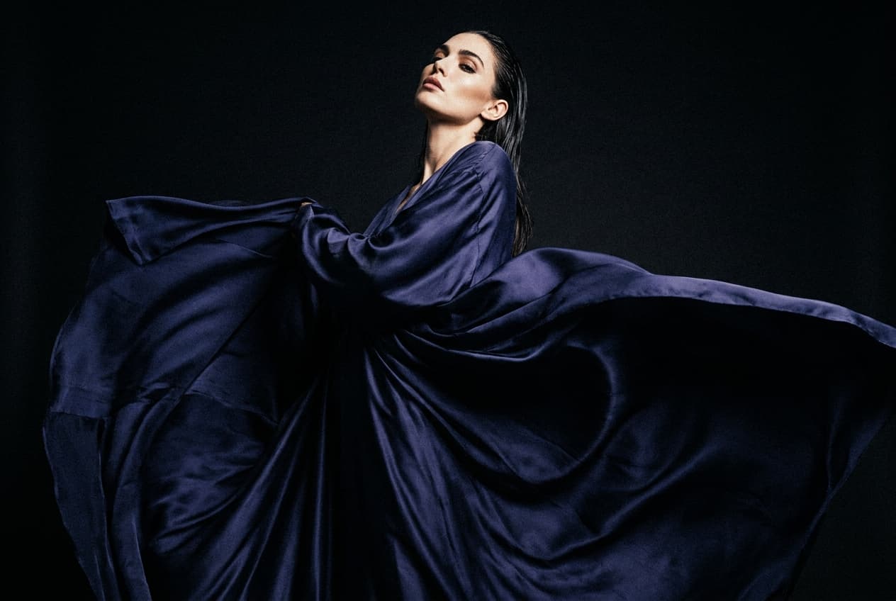 Woman in a navy satin gown posing at eye level against black, made with Nano Banana Pro