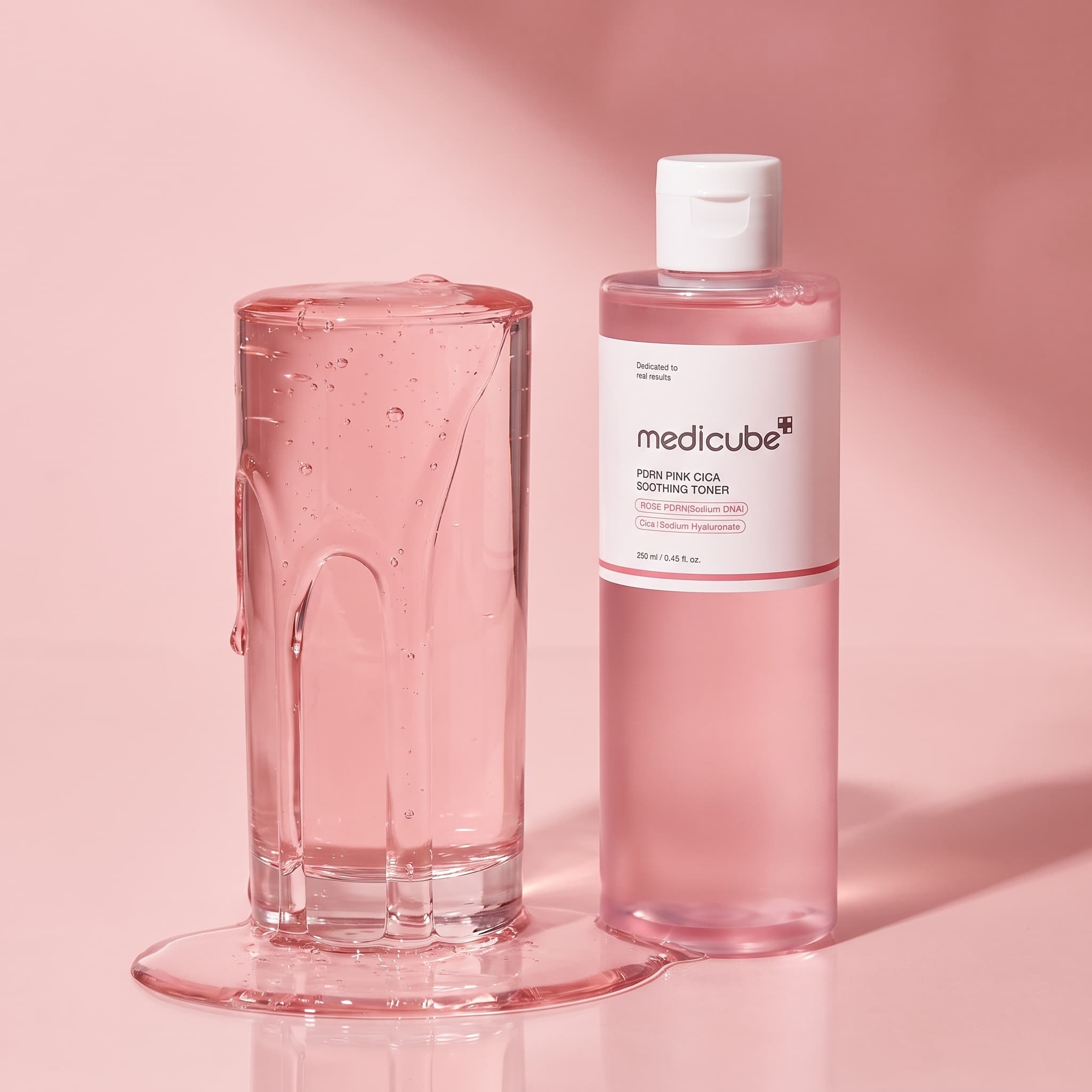 Tall glass overflowing with thick pink liquid beside a pink toner bottle on a pink backdrop, made with Nano Banana Pro