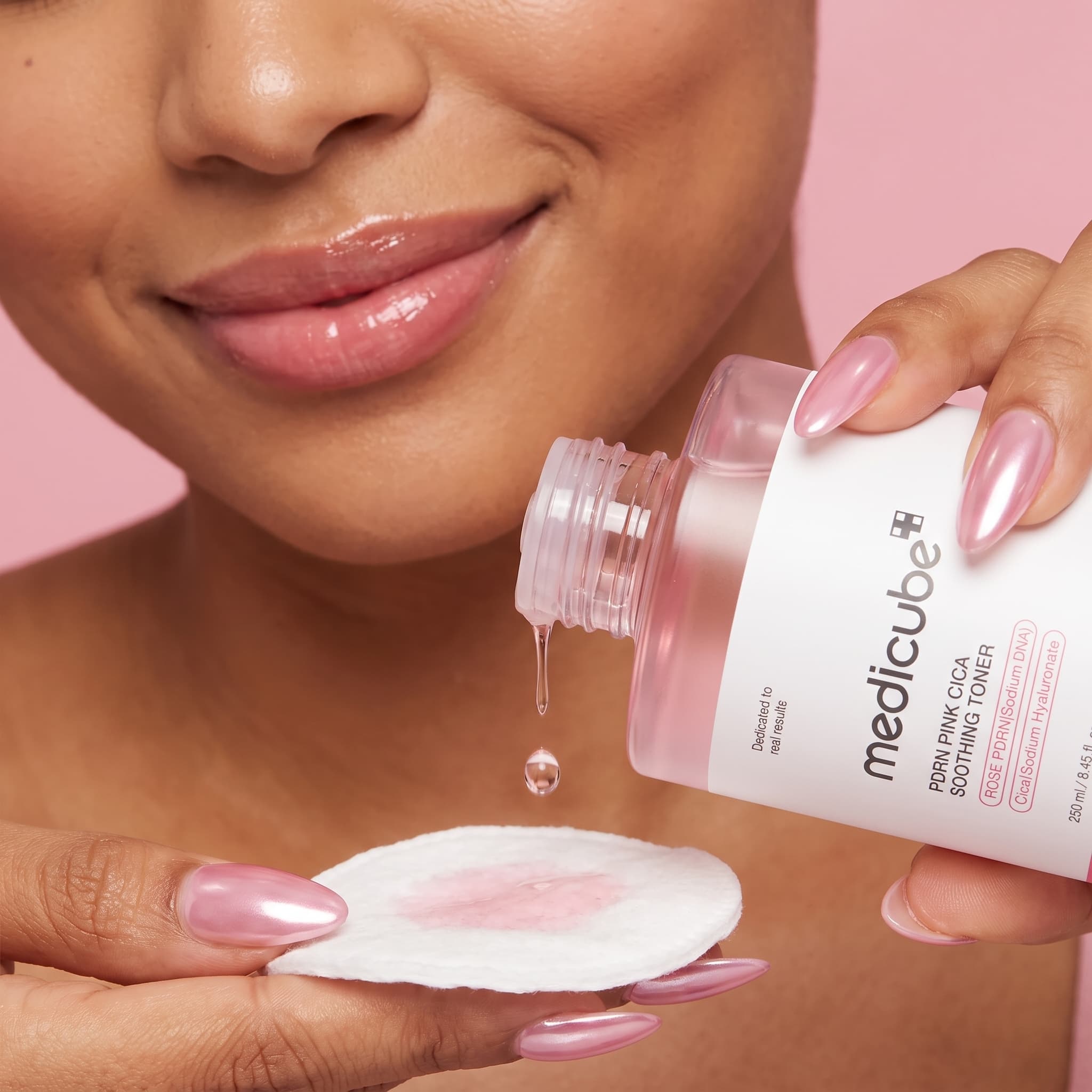 Close-up of glossy lips and pink chrome nails dropping pink toner onto a cotton pad, made with Nano Banana Pro