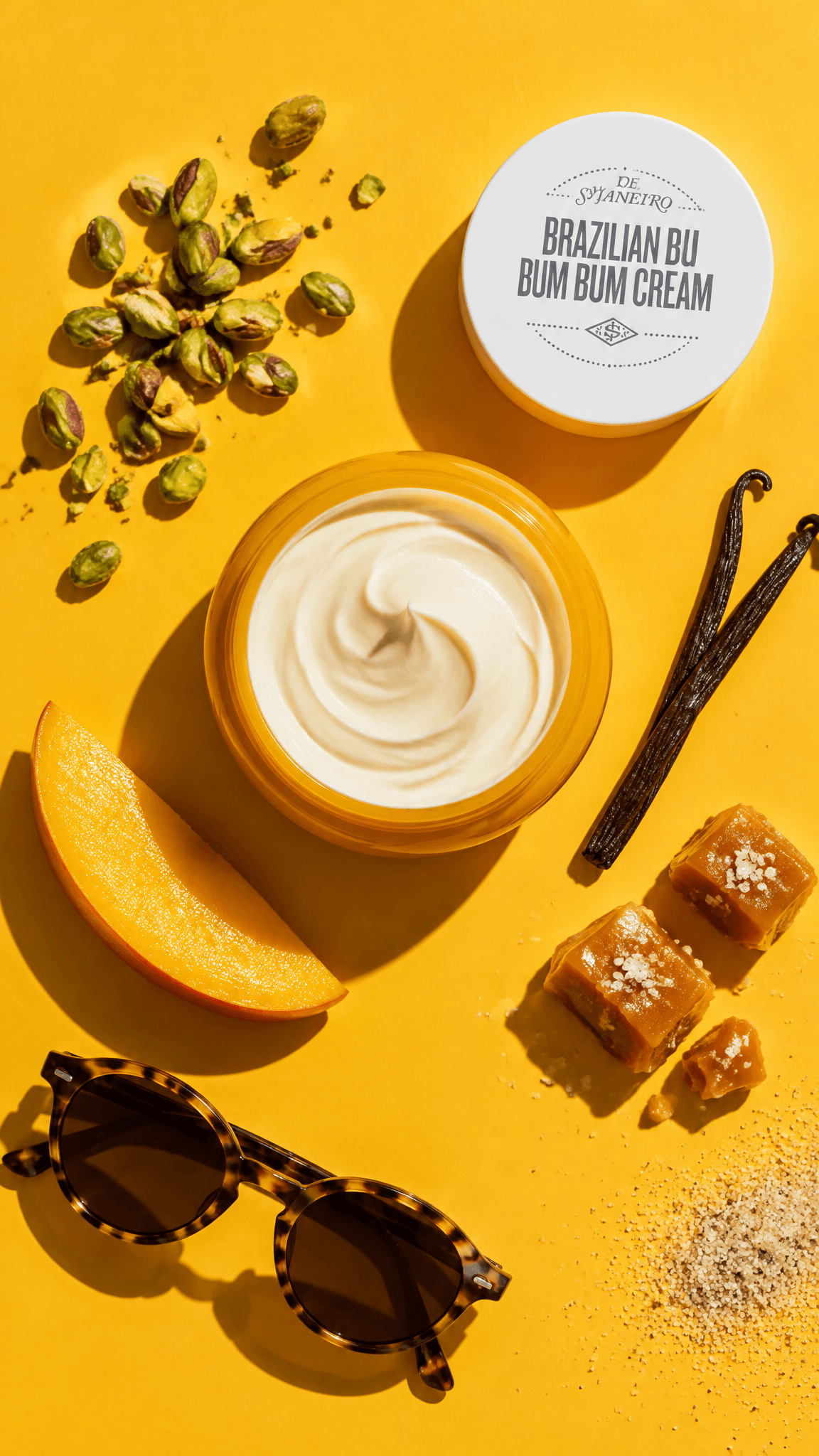 Sol de Janeiro Bum Bum Cream jar open on a yellow surface with a cream swirl and pistachios, top-down, made with GPT Image 2.5 Flare