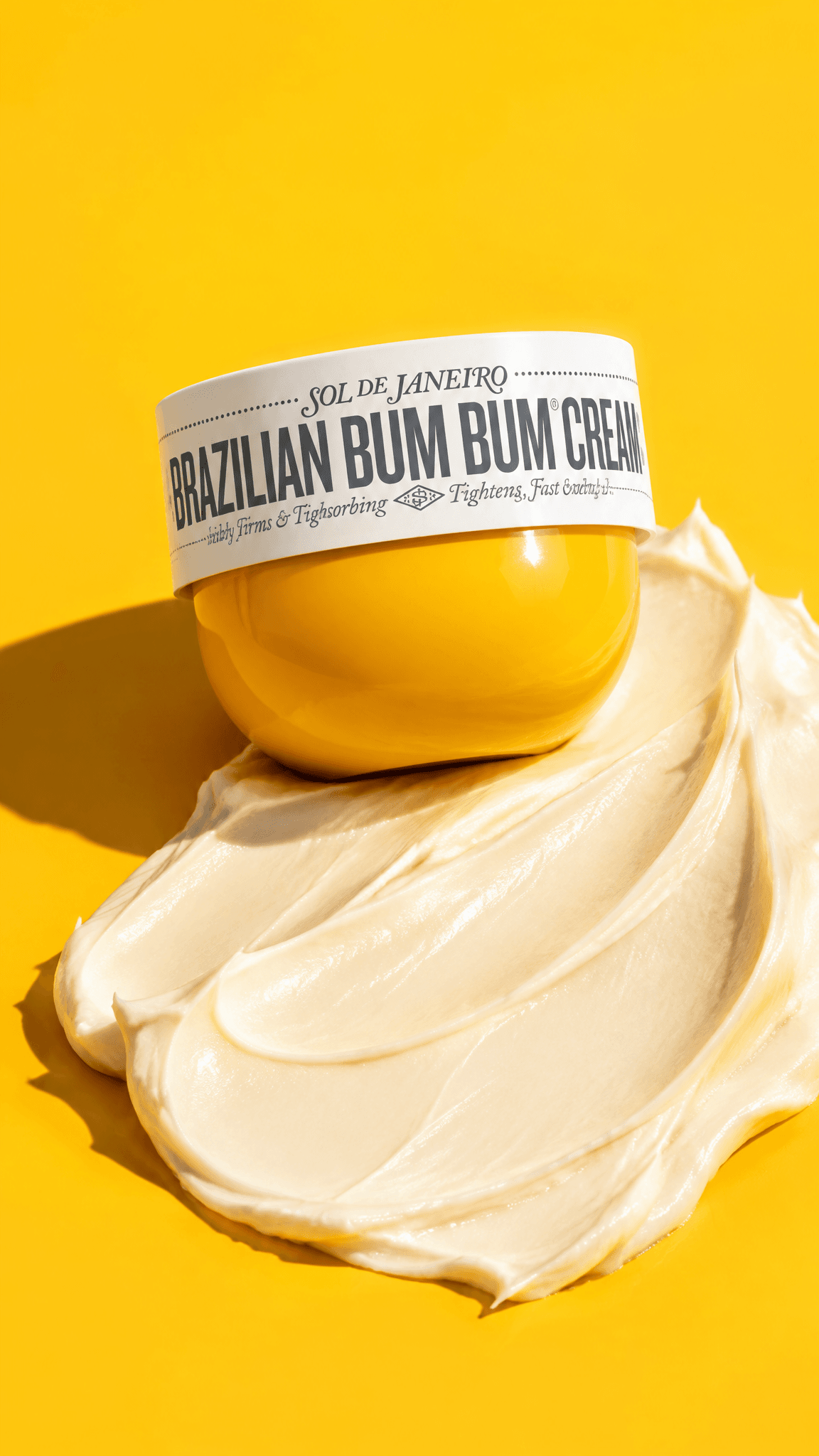 Sol de Janeiro Bum Bum Cream jar on a golden-yellow set with a cream swoosh in hard sun, made with GPT Image 2.5 Flare