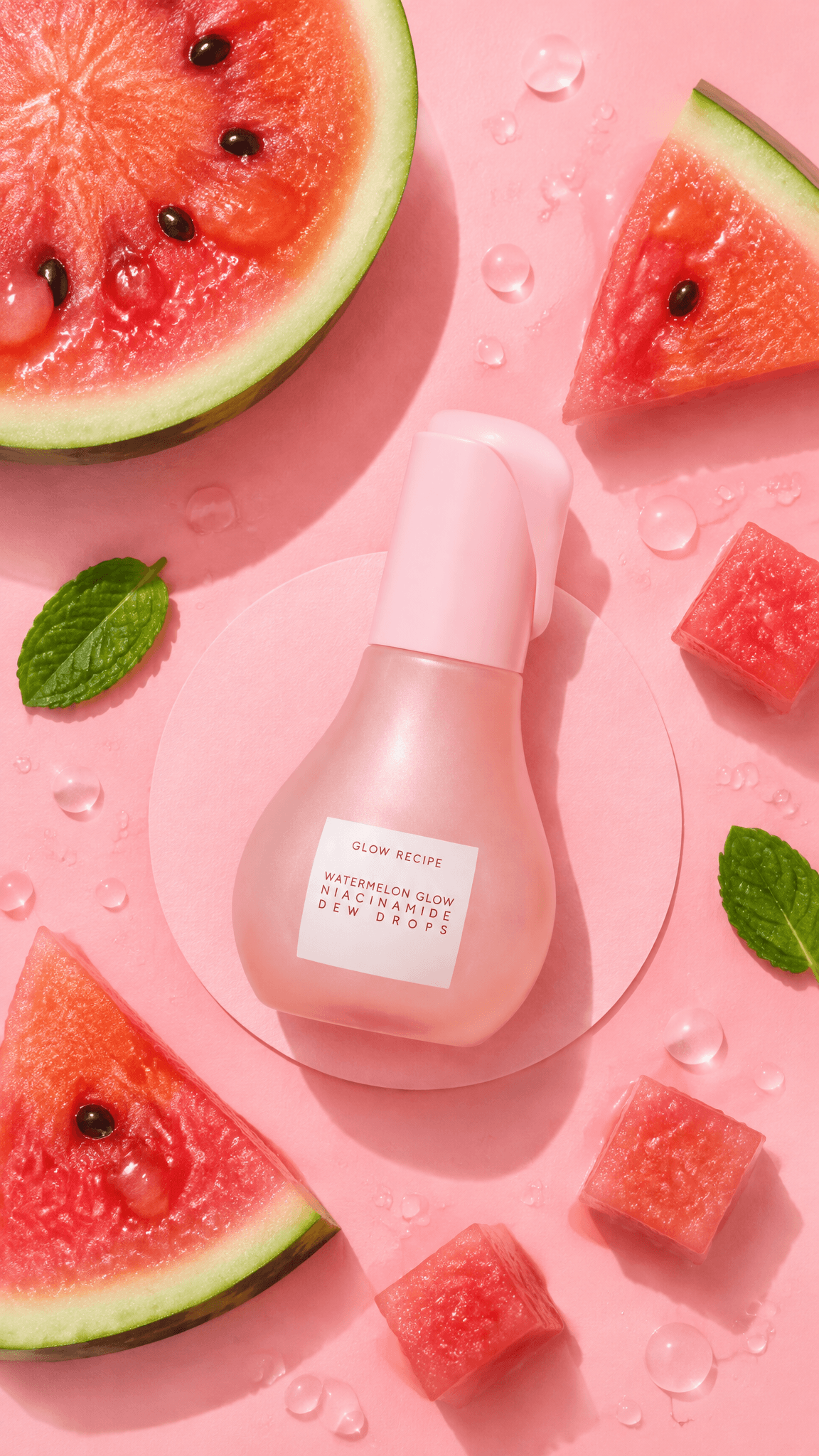 Glow Recipe Dew Drops bottle with halved and sliced watermelon on pink, top-down, made with GPT Image 2.5 Flare