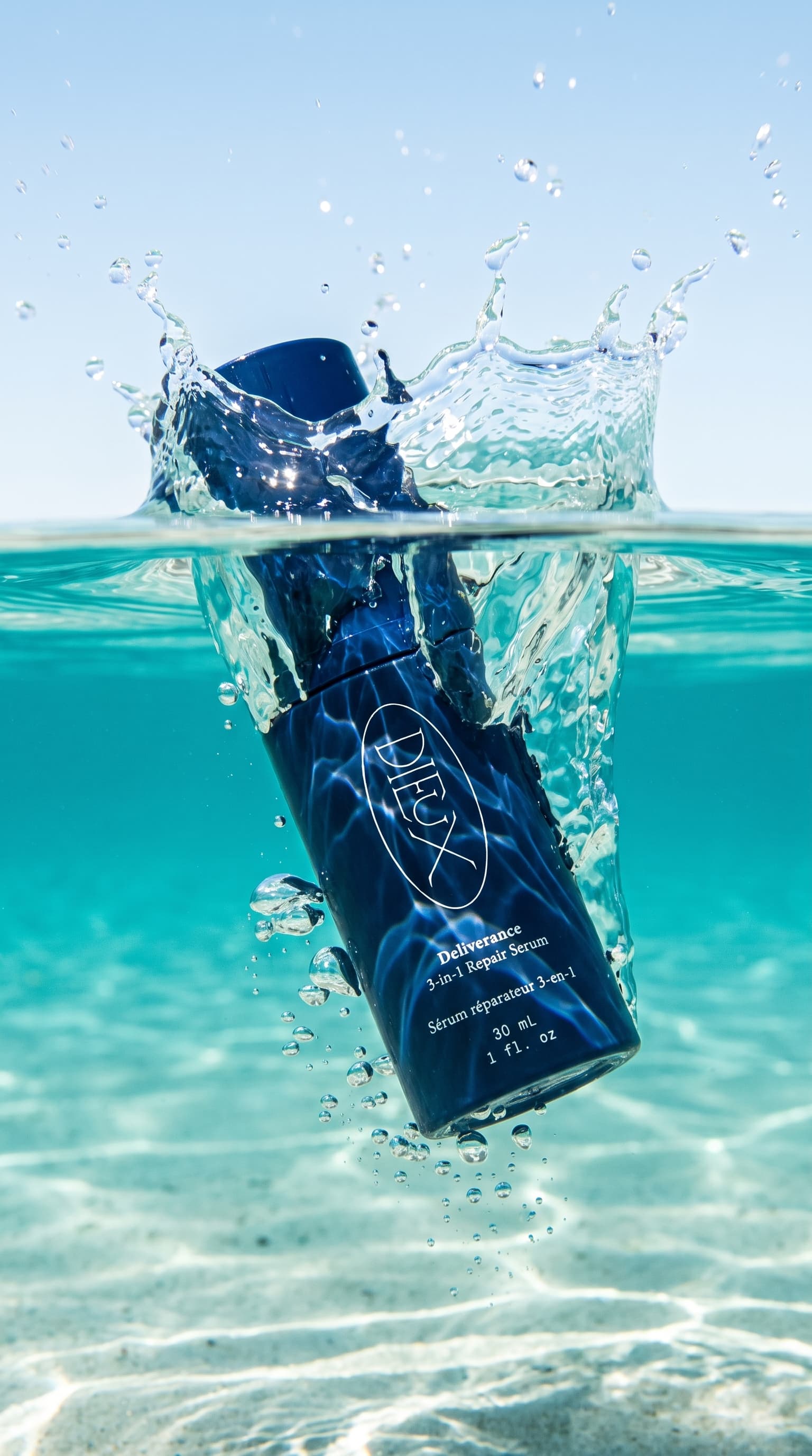 Navy serum bottle splashing into clear turquoise water, shot half above and half below the surface, made with Nano Banana Pro