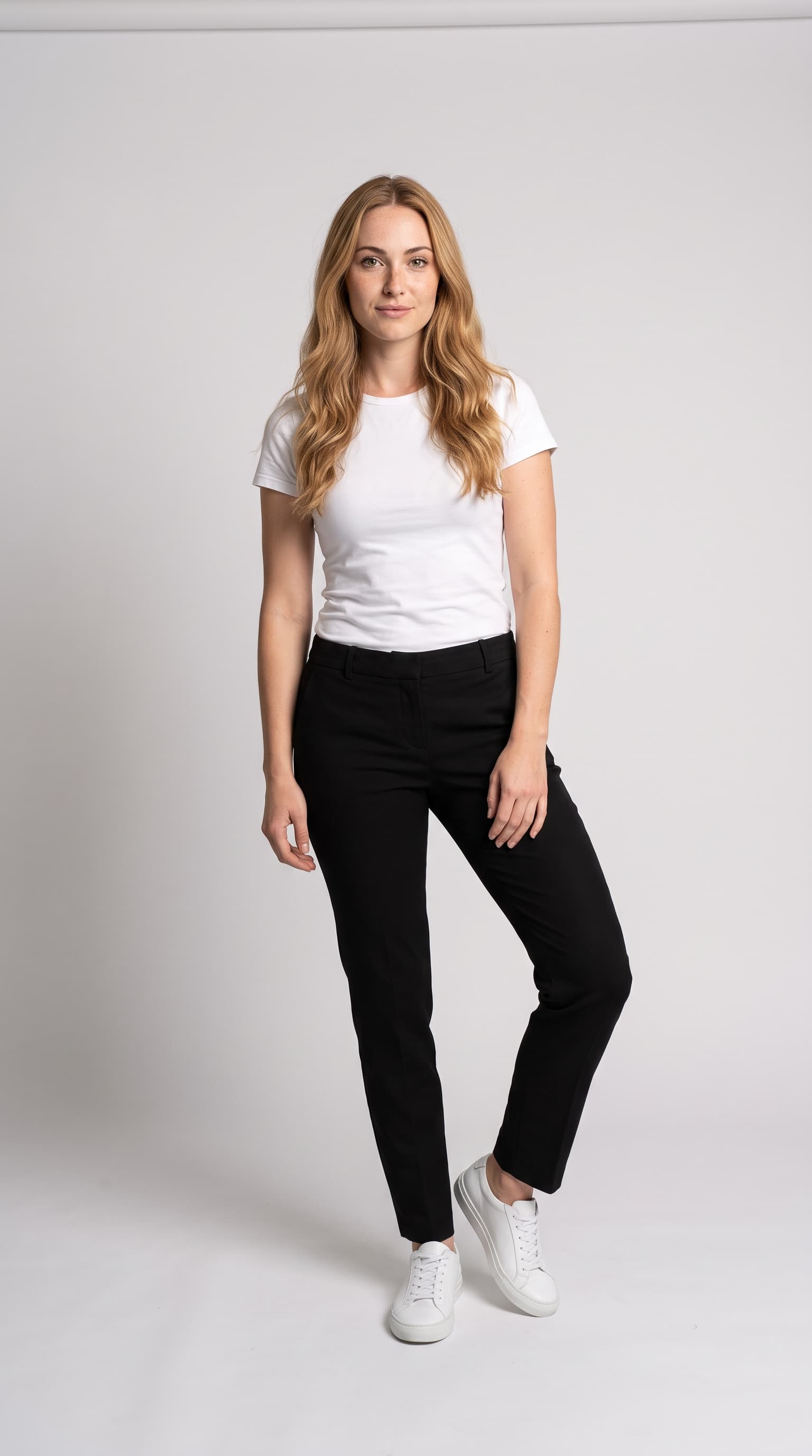 First generic version of a blonde model in a white tee and black trousers on grey paper, made with Nano Banana Pro
