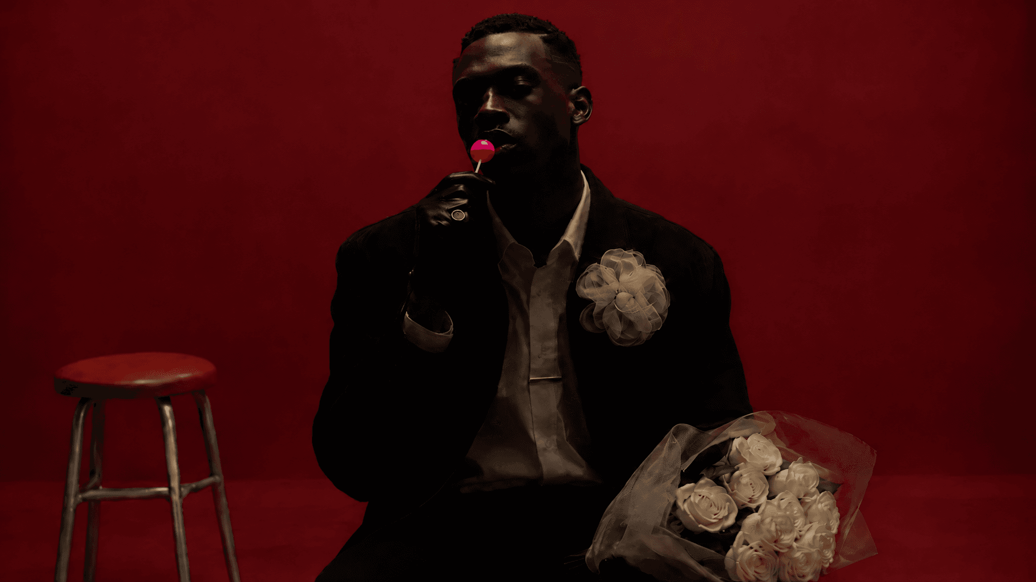 Man in shadow against a bright burgundy wall holding a pink lollipop and a bouquet, made with GPT Image 2.5 Sunburst