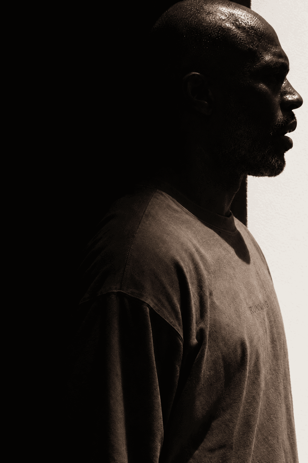 Man in strict profile half dissolved into black against a smooth white wall, made with GPT Image 2.5 Sunburst