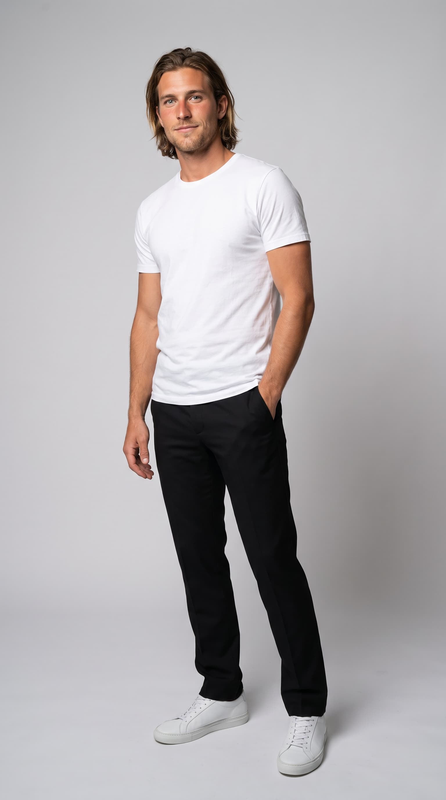 Male model with tousled dark-blond hair, stubble and a half-smile in a white tee on grey paper, made with Nano Banana Pro